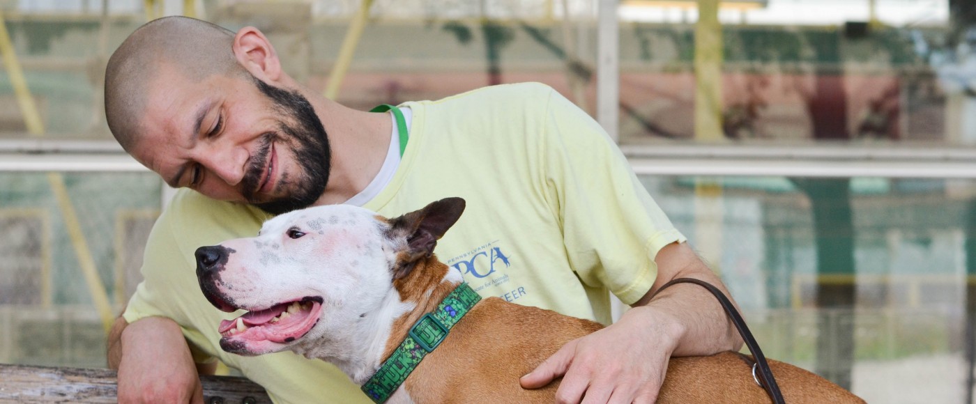 Man sits with dog in his lap